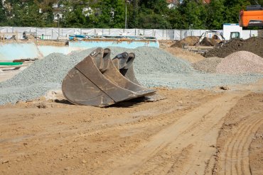 Baggerschaufel Baggerschaufel, die auf einer Baustelle liegt.