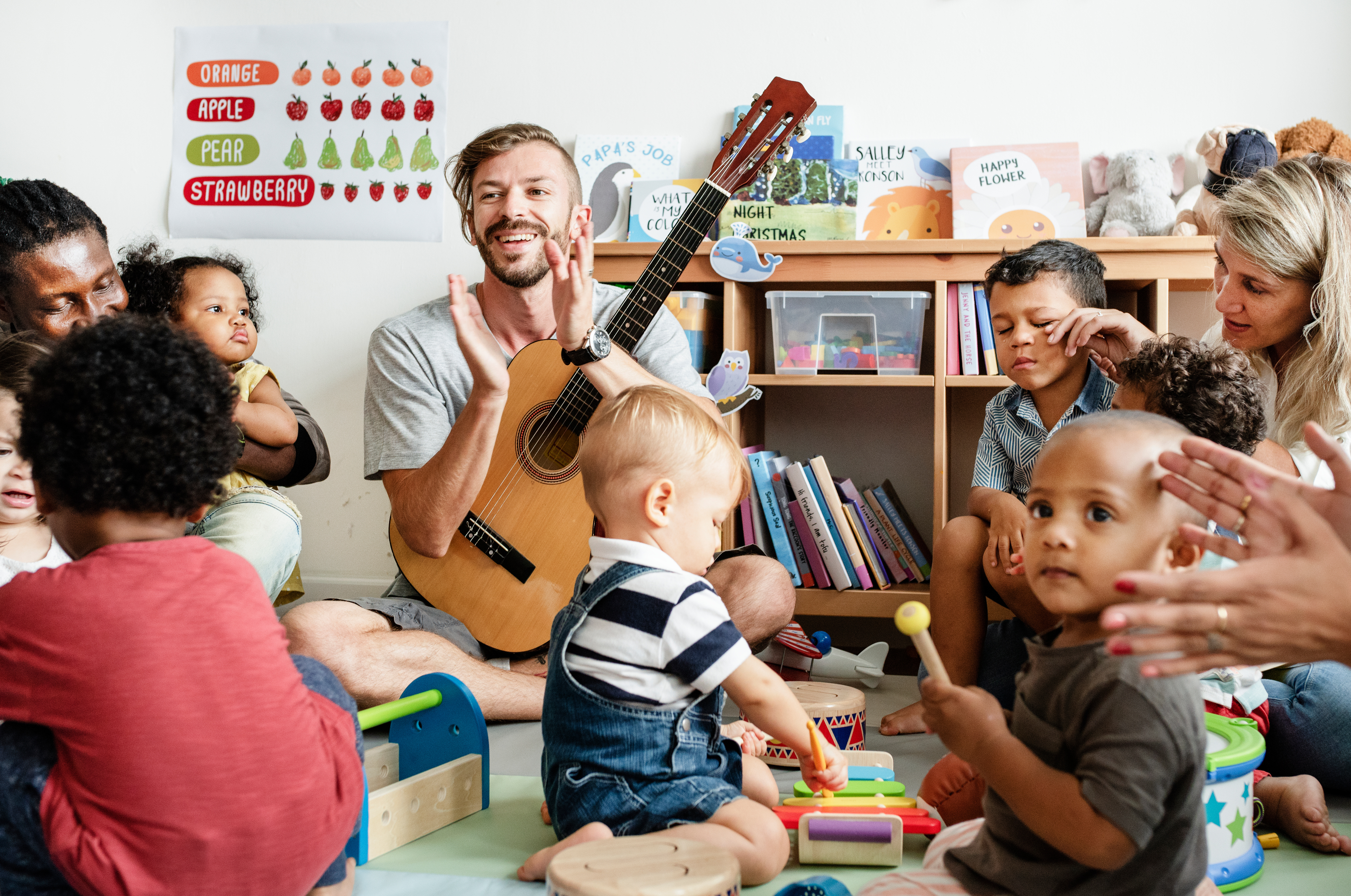 Nursery children playing with musical instruments in the classro Nursery children playing with musical instruments in the classro