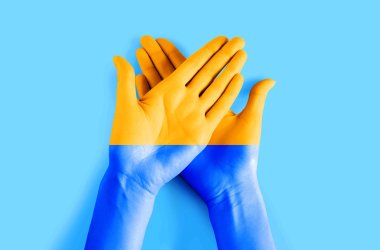 Female hands painted in the colors of the flag of Ukraine. Ukraine Independence Day background, freedom, friendship, unity concept.