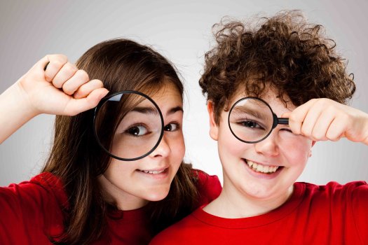 Girl and boy holding magnifying glass