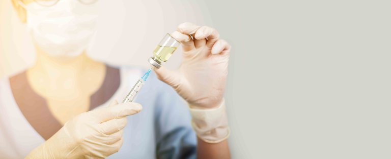 Hand of a doctor or nurse in nitrile gloves with a syringe needle vaccinated against influenza, measles, coronavirus COVID-19 for vaccinating children and adults Hand of a doctor or nurse in nitrile gloves with a syringe needle vaccinated against influenza, measles, coronavirus COVID-19 for vaccinating children and adults