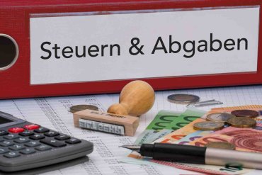 Ordner "Steuern und Abgaben" Roter Aktenordner, der mit dem Aufdruck "Steuern und Abgaben " beschriftet ist,