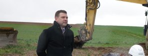 Bürgermeister Silbereis beim Spatenstich Bürgermeister Silbereis steht beim Spatenstich der Firma Datron neben einer Baggerschaufel.