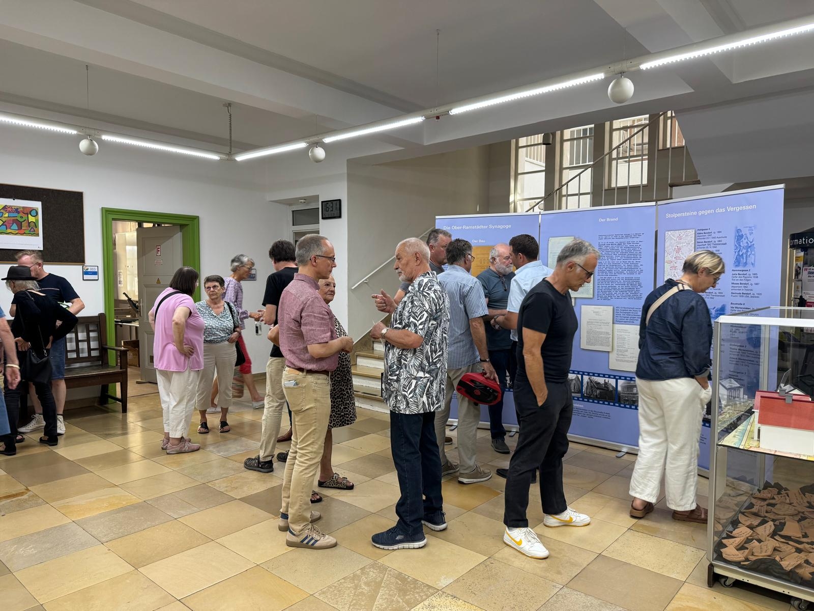 Menschen betrachten historische Infotafeln und Exponate in einer Ausstellung.