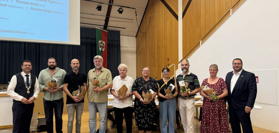 Ausgeschiedene Kommunalpolitiker wurden feierlich verabschiedet Gruppenfoto mehrerer Personen bei einer feierlichen Veranstaltung. Die Teilnehmenden stehen nebeneinander und halten teilweise Urkunden und Präsente in den Händen.