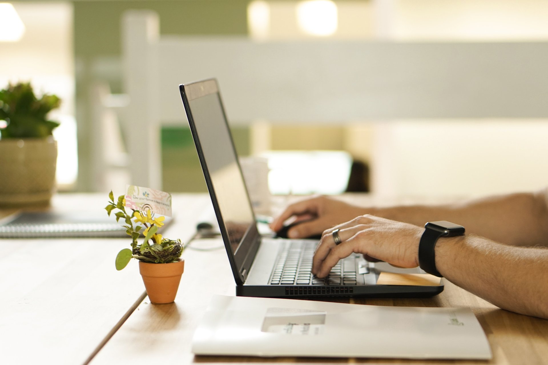 Elektronische Wohnsitzanmeldung nun auch online möglich. Person arbeitet an einem Laptop in einer modernen Büroumgebung und nutzt digitale Werkzeuge für Kommunikation und Organisation.