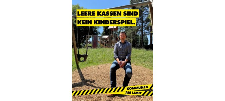 Kommunalpolitiker auf einer Schaukel vor einem Spielplatz. Die Kampagnenbotschaft „Leere Kassen sind kein Kinderspiel“ verweist auf die finanziellen Herausforderungen der Kommunen.