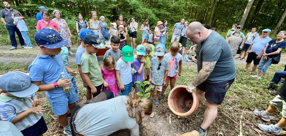 Kinder pflanzen im Wald einen Baum