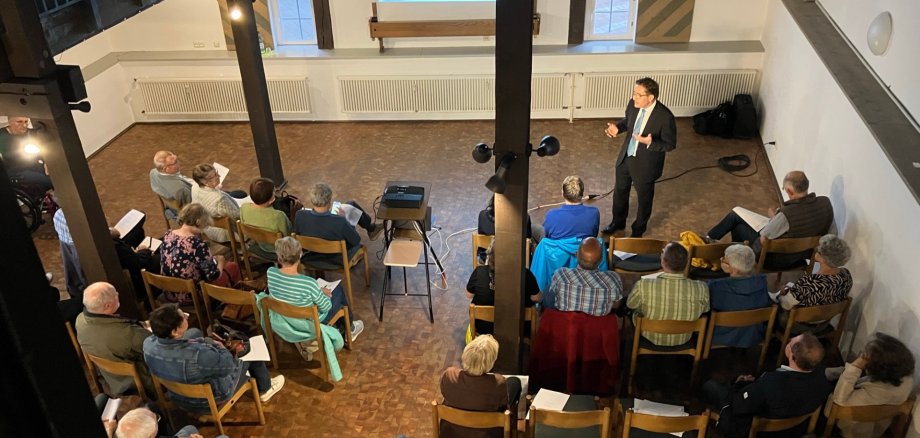 Personen in einem Saal die einen Vortrag besuchen