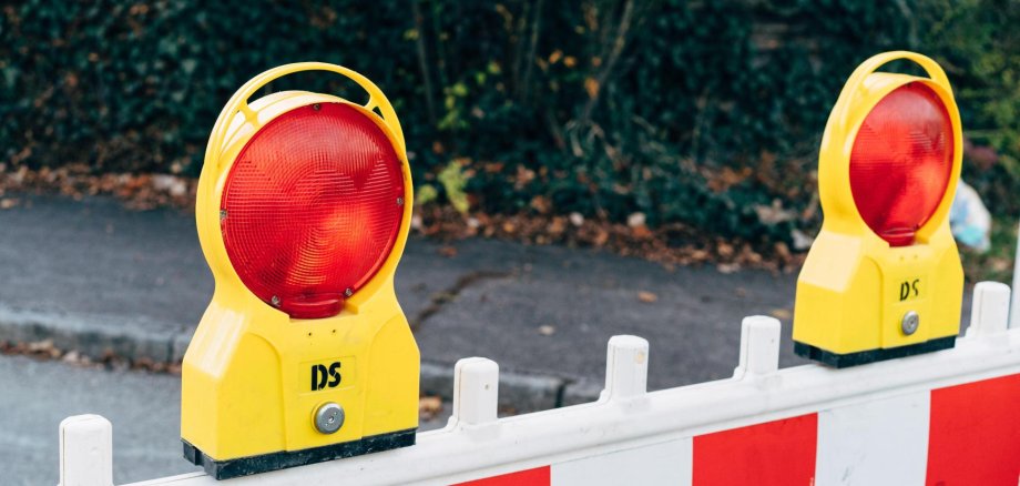 Verkehrseinschränkungen und Straßensperrungen wegen einer Veranstaltung. Baustellenabsperrung mit Warnleuchten im öffentlichen Raum.