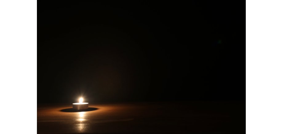 Burning candle over black background