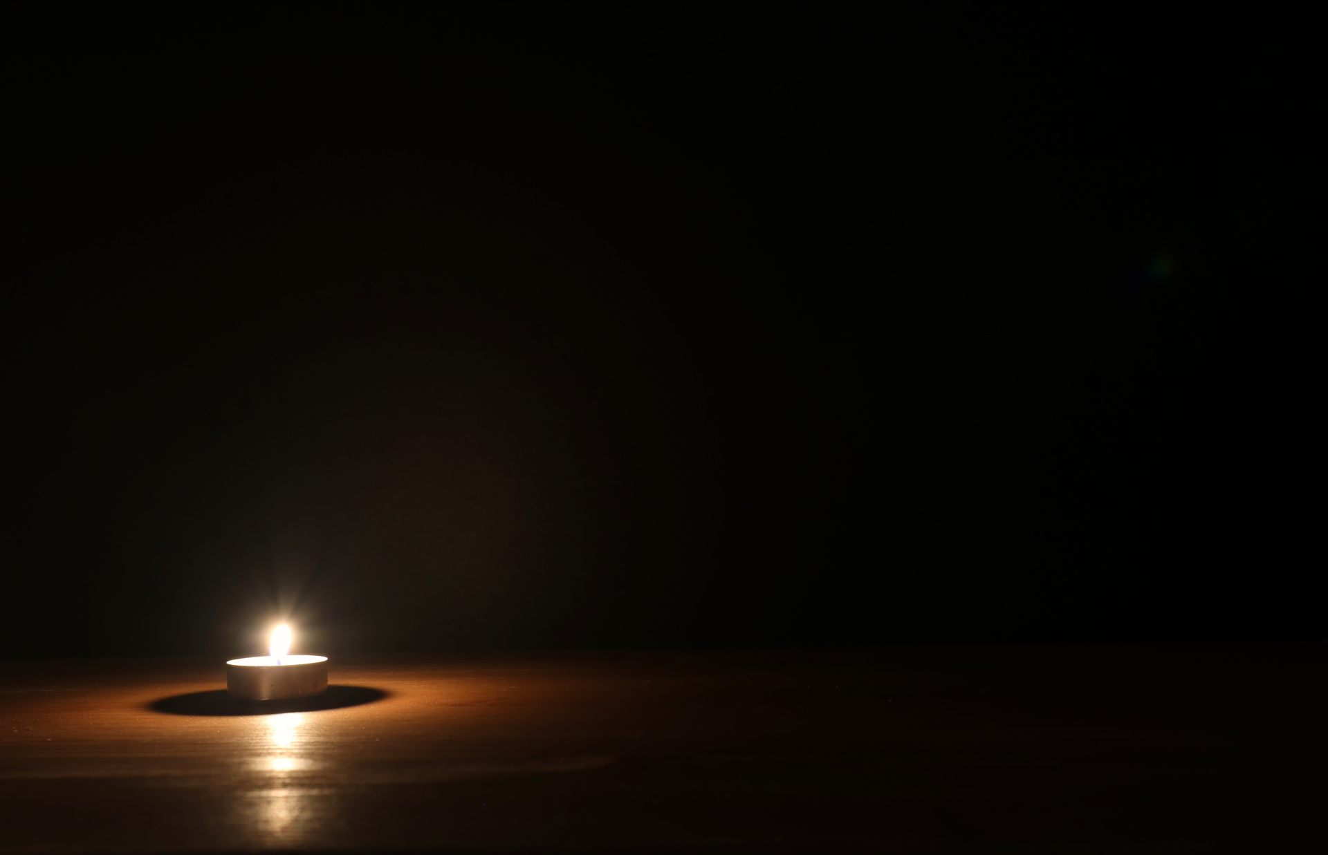 Burning candle over black background