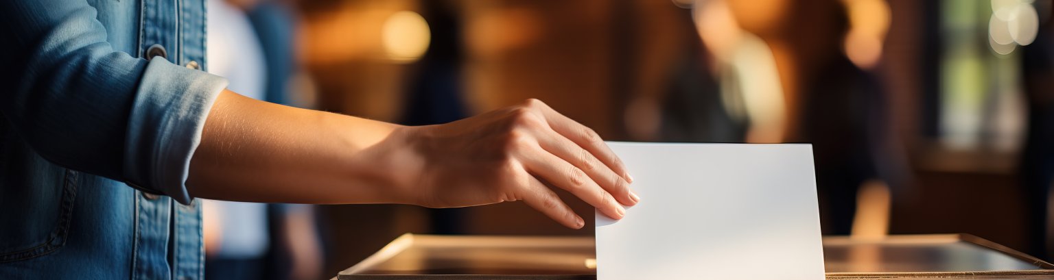 Hand of a woman voting at a ballot box during elections